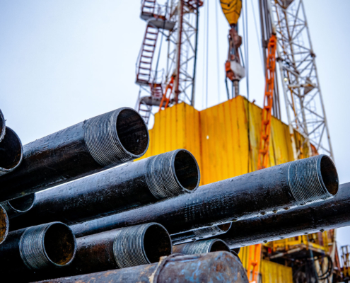 Side view of rusty pipes next to oil rig