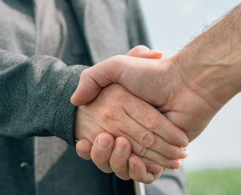 Mortgage loan officer and farmer shaking hands upon reaching an agreement