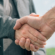 Mortgage loan officer and farmer shaking hands upon reaching an agreement
